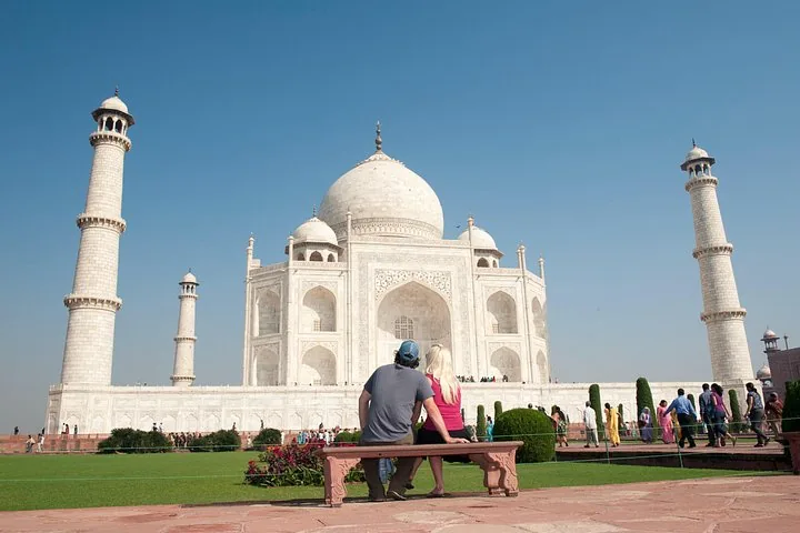Couple assis sur un banc regardant le Taj Mahal